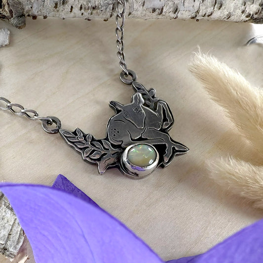 Silver pendant with opal stone on a textured surface